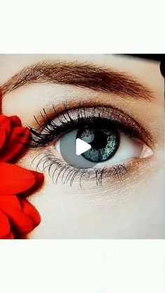 a woman's eye with red flowers in front of her