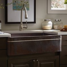 a kitchen sink sitting under a window next to a faucet and counter top