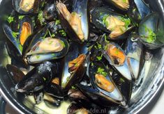 steamed mussels with parsley in a pot on the stove top, ready to be eaten