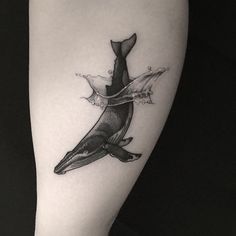 a black and white photo of a whale tattoo