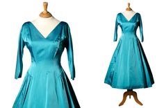 "| d e s c r i p t i o n | 1950s Tea-length dress in beautiful teal-blue satin. This stunning dress is perfect for an evening out or special occasion. The colour is so lovely, not overly saturated but still a nice unique rich colour.  Featuring a classic 1950s fit and flare silhouette, this dress have a V neckline, 3/4 sleeves and an empire waistline.  There is a drop waist style detail and a very full skirt.  The fabric has a little weight to it and is in fantastic condition.  Centre back metal Satin Tea Length Dress, Tea Length Dress, Empire Waistline, Teal Dress, Tea Length Dresses, Teal And Pink, Tea Length, Blue Satin, Drop Waist