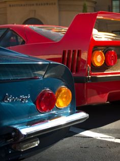 two classic cars parked next to each other in a parking lot with the tail lights on