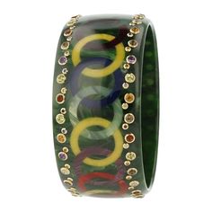 Part of the exclusive Mark Davis Collector Line, this vintage, marbled green bakelite bangle has been inlaid with a pattern of interlocking rings creating an endless chain that wraps around the bangle. The outer margins of the bangle have been set with a variety of larger and smaller gemstones, all mounted in 18k yellow gold bezels. Eye-catching amethyst, citrine, peridot, smoky quartz, blue, pink and yellow sapphire, ruby and white topaz make this one-of-a-kind bangle very special. Technically challenging to create, this bangle epitomizes the combination of artistry and skill that Mark Davis imbues in the pieces from the Collector Line. Metal 18-Karat Yellow Gold (Au750) Gemstones Amethyst 1.06 ctwCitrine 2.05 ctwPeridot 1.56 ctwSmoky Quartz 0.87 ctwRuby 0.13 ctwBlue Sapphire 0.14 ctwPink Interlocking Rings, Interlocking Ring, Bakelite Bangles, Pink And Yellow, Yellow Sapphire, A Pattern, White Topaz, Smoky Quartz, Citrine