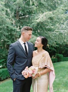 a man in a suit and tie standing next to a woman wearing a wedding dress