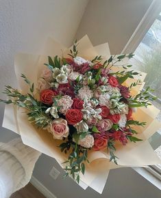 a bouquet of flowers sitting on top of a window sill next to a wall