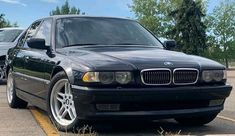 a black bmw parked in a parking lot