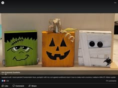 three wooden boxes with faces painted on them, one has a jack - o'- lantern