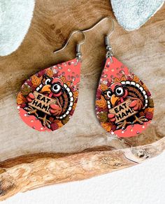 a pair of earrings with an image of a turkey on it and the words eat ham