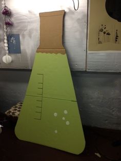 a cardboard cut out of a tall green tower with a ruler on it's side