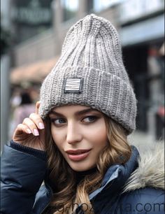 a woman wearing a gray hat and jacket