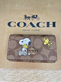 a coach wallet with peanuts on it