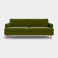 a green couch sitting on top of a white floor