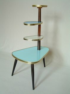 a three tiered shelf with blue glass and gold trimmings on the bottom