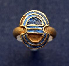 a gold and blue ring with an eye on it