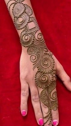 a woman's hand with henna tattoos on it