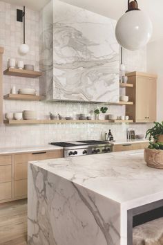 a kitchen with marble counter tops and wooden cabinets, along with an island in the middle