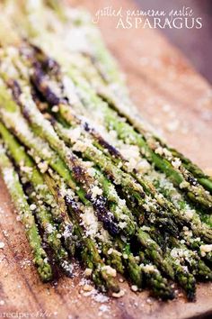 asparagus on a wooden cutting board with parmesan sprinkles