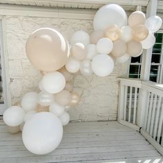 white balloons are floating in the air on a porch