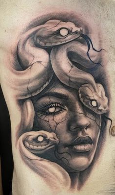 a man's chest with an image of a woman and two snakes on it