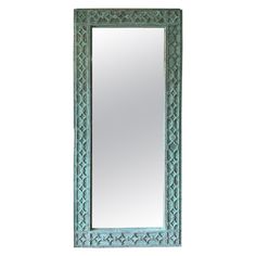 a mirror that is sitting on top of a wall next to a white wall with a blue frame