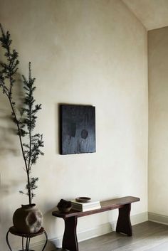 a room with a table, chair and potted plant