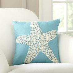 a starfish pillow sitting on top of a white chair