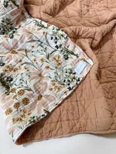 an orange and white quilted blanket with flowers on it