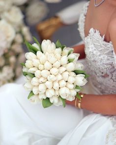 a bride holding a bouquet of white flowers