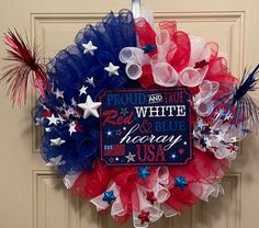 a red, white and blue wreath hanging on a door with the words proud usa written on it