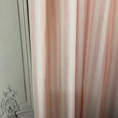 a pink and white striped shower curtain next to a door with an ornate design on it