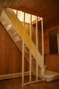 a wooden staircase in an unfinished room with wood paneling