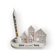 a pen and some paper houses on a white stand with the words home sweet home