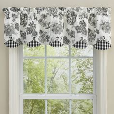 the window is decorated with black and white floral curtains, which are lined with gingham checkers