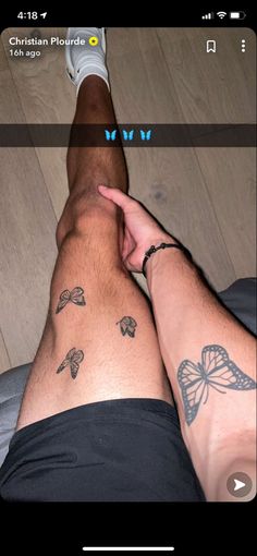 a man with tattoos on his legs sitting down