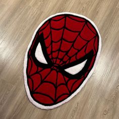 a close up of a spiderman rug on a wooden floor