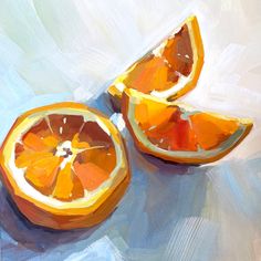 an orange cut in half sitting on top of a blue table cloth next to another piece of fruit