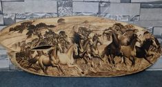 a wooden plaque with horses on it in front of a brick wall