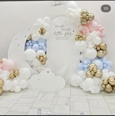 balloons are arranged in the shape of an elephant and clouds with gold, white, and blue accents