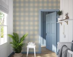 a baby's room with a blue door and green plant in the corner next to it