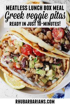 two pita breads with vegetables and chickpeas are on a white plate