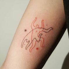 a tattoo on the arm of a woman with an orange outline of a dog and stars