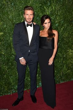 a man and woman in formal wear standing next to each other on a red carpet