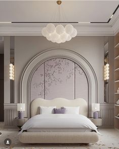 a large white bed sitting under a chandelier in a bedroom next to a book shelf