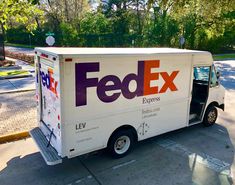 the fed ex express truck is parked on the side of the road