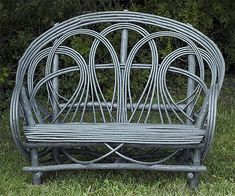 a bench made out of wicker sitting in the grass