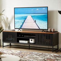 a flat screen tv sitting on top of a wooden stand