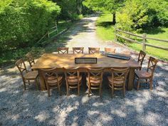 a wooden table with chairs and a radio on it in the middle of a gravel road