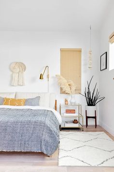 a bedroom with white walls and wood floors