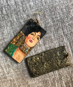 a keychain with an image of a woman on it next to a purse