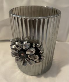 a silver vase with some crystal flowers in it's center on a white table cloth